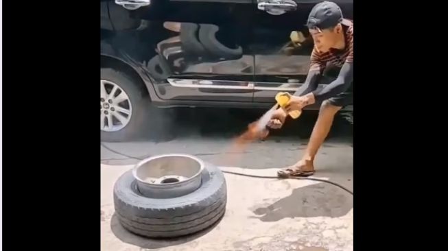 Pasang ban mobil menggunakan obat nyamuk semprot (Facebook)