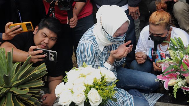 Mantan Politikus Angelina Sondakh berziarah ke makam suaminya, Adjie Massaid di TPU Jeruk Purut, Jakarta, Kamis (3/3/2022). [Suara.com/Angga Budhiyanto]
