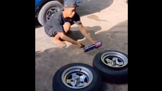 Pasang ban mobil menggunakan obat nyamuk semprot (Facebook)