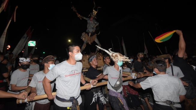 Umat Hindu mengarak ogoh-ogoh saat pawai menyambut Hari Raya Nyepi Tahun Baru Saka 1944 di Denpasar, Bali, Rabu (2/3/2022).  ANTARA FOTO/Nyoman Hendra Wibowo