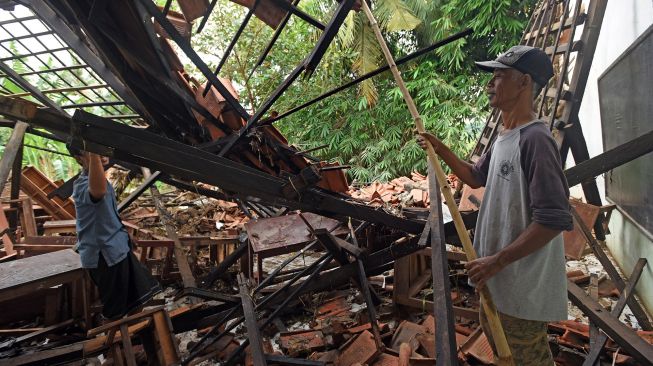 Warga membersihkan puing-puing bangunan sekolah Madrasah Aliyah Madarisul Ulum di Kampung Kenari, Kasemen, Serang, Banten, Jumat (4/3/2022). ANTARA FOTO/Asep Fathulrahman