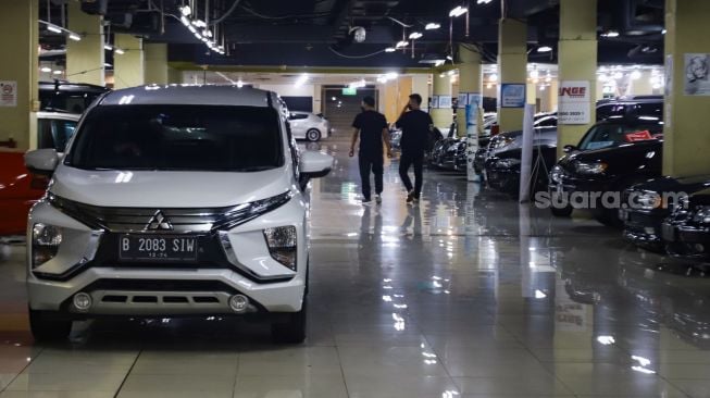 Pengunjung melihat mobil di bursa mobil bekas, blok M, Jakarta Selatan, Jumat (4/3/2022). [Suara.com/Alfian Winanto]