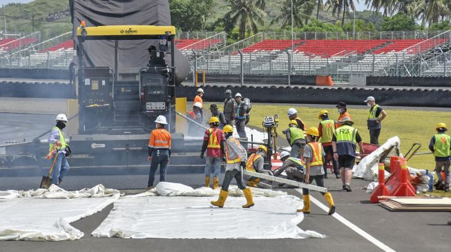 Sejumlah pekerja mengerjakan pengaspalan ulang tikungan ke-17 lintasan Pertamina Mandalika International Street Circuit di KEK Mandalika, Kecamatan Pujut, Praya, Lombok Tengah, NTB, Sabtu (5/3/2022). ANTARA FOTO/Ahmad Subaidi
