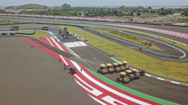 Sejumlah pekerja mengerjakan pengaspalan ulang tikungan ke-17 lintasan Pertamina Mandalika International Street Circuit di KEK Mandalika, Kecamatan Pujut, Praya, Lombok Tengah, NTB, Sabtu (5/3/2022). ANTARA FOTO/Ahmad Subaidi
