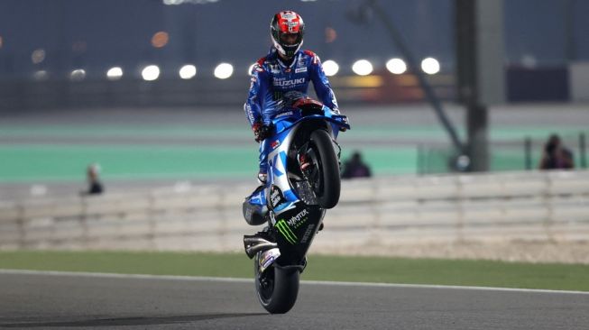 Pembalap Suzuki Ecstar, Alex Rins melakukan selebrasi wheelie usai jadi yang tercepat di FP2 MotoGP Qatar di Sirkuit Losail. [KARIM JAAFAR / AFP]