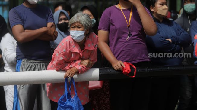 Sejumlah warga mengantre untuk membeli minyak goreng saat operasi pasar di Polsek Tebet, Jakarta, Sabtu (5/3/2022). [Suara.com/Angga Budhiyanto]