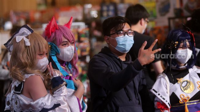 Pengunjung berfoto bersama cosplayer tokoh fiksi anime Jepang pada gelaran "The Jakarta 17th Toys & Comics Fair 2022" di Balai Sudirman, Jakarta, Sabtu (5/3/2022). [Suara.com/Angga Budhiyanto]