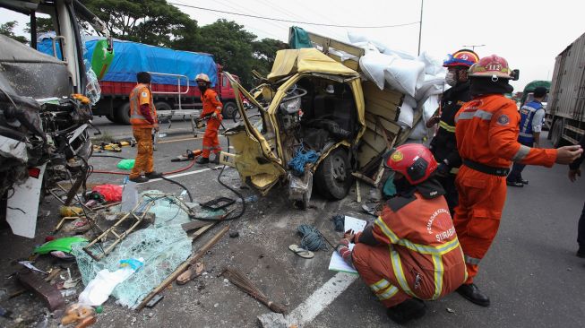 Petugas mengevakuasi bus pariwisata dan truk yang terlibat kecelakaan di Tol Dupak - Tanjung Perak Surabaya, Jawa Timur, Sabtu (5/3/2022). ANTARA FOTO/Didik Suhartono
