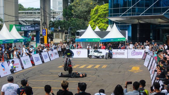 Pengunjung melihat atraksi motor saat Pameran UMKM Goes To Mandalika di Gedung Smesco, Jakarta Selatan, Minggu (6/3/2022). [Suara.com/Septian]