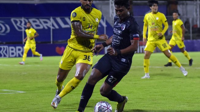 Pesepak bola Arema FC Dedik Setiawan (kanan) berebut bola dengan pesepak bola Barito Putera Renan Alves (kiri) pada pertandingan Liga 1 di Stadion Kompyang Sujana, Denpasar, Bali, Sabtu (5/3/2022). [ANTARA FOTO/Nyoman Hendra Wibowo/wsj]