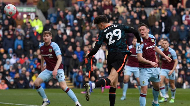 Gelandang Chelsea Kai Havertz (tengah) menyundul bola dan mencetak gol kedua untuk timnya saat pertandingan sepak bola Liga Premier Inggris antara Burnley dan Chelsea di Stadion Turf Moor, Inggris, Sabtu (5/3/2022). [Oli SCARFF / AFP]