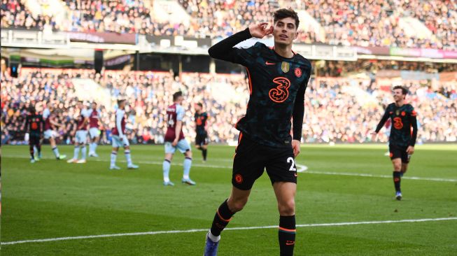 Gelandang Chelsea Kai Havertz melakukan selebrasi setelah mencetak gol kedua untuk timnya saat pertandingan sepak bola Liga Premier Inggris antara Burnley dan Chelsea di Stadion Turf Moor, Inggris, Sabtu (5/3/2022). [Oli SCARFF / AFP]