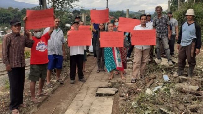 Kampung Pasirjambu, Kelurahan Empang, Kecamatan Bogor Selatan, Kota Bogor menggelar aksi menuntut pembangunan JPO, Minggu (6/3/2022). [Bogordaily.net]