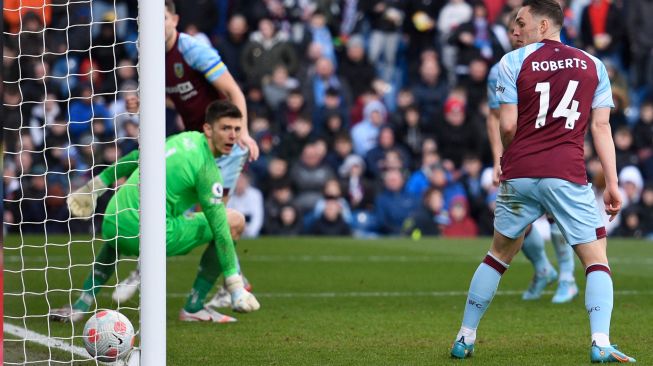 Bek Burnley, Connor Roberts (kanan) dan kiper Inggris Burnley Nick Pope (kiri) melihat bola yang ditembakkan oleh bek Chelsea Inggris Reece James memasuki gawang saat pertandingan sepak bola Liga Premier Inggris antara Burnley dan Chelsea di Stadion Turf Moor, Inggris, Sabtu (5/3/2022). [Oli SCARFF / AFP]