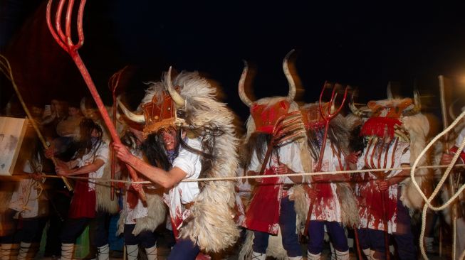 Orang-orang mengenakan kostum Momotxorro saat karnaval tradisional Alsasua di Alsasua, provinsi Navarra, Spanyol, Selasa, (1/3/2022). [ANDER GILLENEA / AFP]