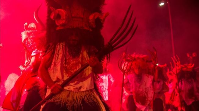 Orang-orang mengenakan kostum Momotxorro saat karnaval tradisional Alsasua di Alsasua, provinsi Navarra, Spanyol, Selasa, (1/3/2022). [ANDER GILLENEA / AFP]