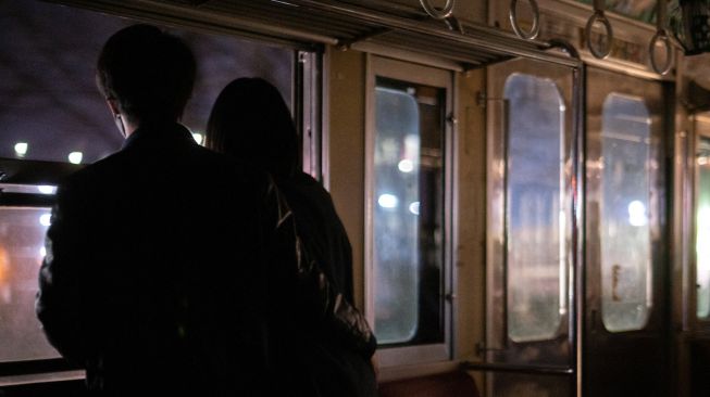 Penumpang menaiki kereta yang populer untuk tur wisata malam hari yang melintasi jalur kereta Gakunan melalui kawasan industri di Fuji, prefektur Shizuoka, Jepang, Sabtu (26/2/2022). [Philip FONG / AFP]