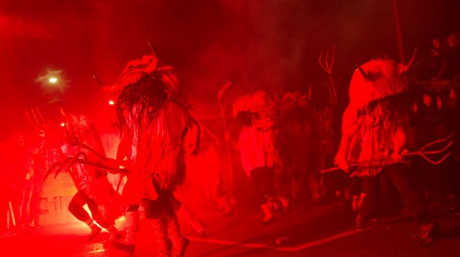 Orang-orang mengenakan kostum Momotxorro saat karnaval tradisional Alsasua di Alsasua, provinsi Navarra, Spanyol, Selasa, (1/3/2022). [ANDER GILLENEA / AFP]