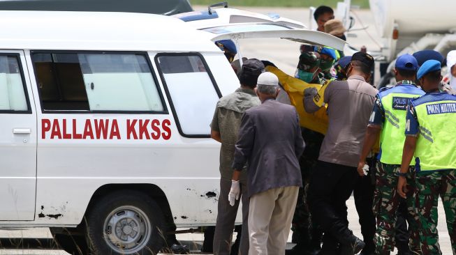 Petugas kepolisian dan TNI membawa kantong berisi jenazah teknisi tower telekomunikasi PT Palapa Timur Telematika (PTT) setibanya di Bandara Mozes Kilangin Timika, Papua, Senin (7/3/2022). [ANTARA FOTO/Saldi Hermanto/wpa/rwa]