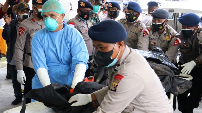 Petugas kepolisian dan petugas medis membawa kantong berisi jenazah teknisi tower telekomunikasi PT Palapa Timur Telematika (PTT) setibanya di RSUD Timika, Papua, Senin (7/3/2022). [ANTARA FOTO/Saldi Hermanto/wpa/rwa]