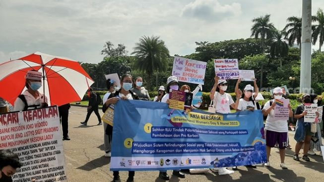 Sejumlah organisasi perempuan menggelar Aksi Bersama di Hari Perempuan Internasional di kawasan Patung Kuda Arjuna Wiwaha, kawasan Silang Monas, Jakarta, Selasa (8/3/2022).(Suara.com/Ummi HS) 