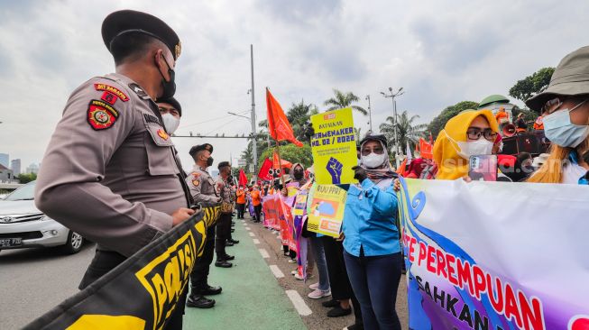 Sejumlah buruh perempuan yang tergabung dalam berbagai serikat melakukan aksi unjuk rasa di depan Gedung DPR RI, Senayan, Jakarta Pusat, Selasa (8/3/2022). [Suara.com/Alfian Winanto]