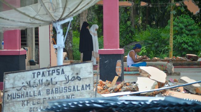 Warga melaksanakan shalat zuhur di mushalla yang rusak akibat gempa di Lubuk Panjang, Nagari Kajai, Kabupaten Pasaman Barat, Sumatera Barat, Selasa (8/3/2022). ANTARA FOTO/Iggoy el Fitra