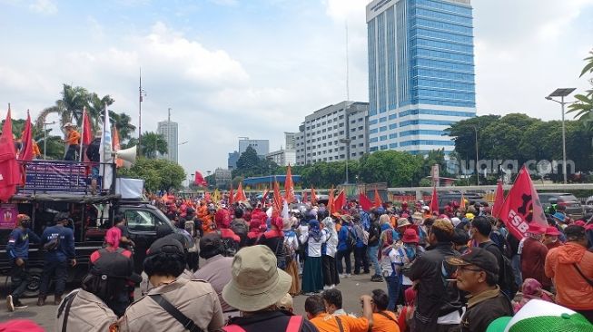 Massa buruh saat menggelar aksi untuk memperingati hari perempuan internasional di gedung DPR RI. (Suara.com/Bagaskara)