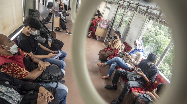 Penumpang duduk tanpa berjarak di dalam KRL Commuter Line, Jakarta, Rabu (9/3/2022).  ANTARA FOTO/Muhammad Adimaja
