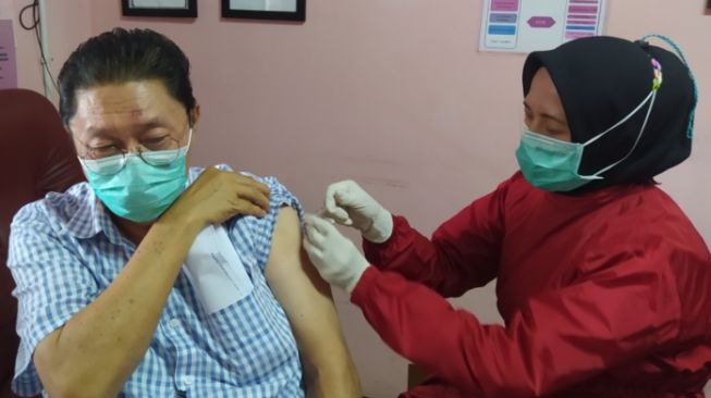 An elderly person in Cimahi City takes part in the third dose of COVID-19 vaccination. [Suara.com/Ferrye Bangkit Rizki]
