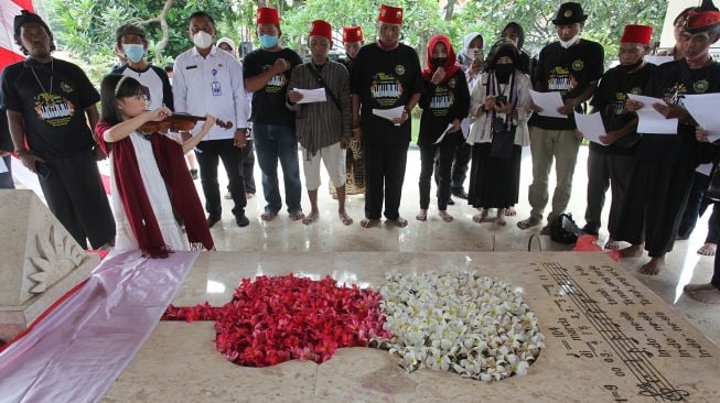 Warga berziarah di makam WR Soepratman di Surabaya, Jawa Timur, Rabu (9/3/2022). ANTARA FOTO/Didik Suhartono
