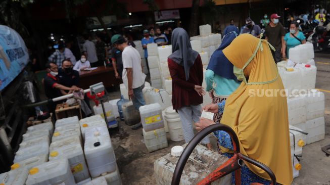 Sejumlah pedagang mengantre untuk mendapatkan minyak goreng curah di Pasar Kebayoran Lama, Jakarta, Rabu (9/3/2022). [Suara.com/Angga Budhiyanto] 