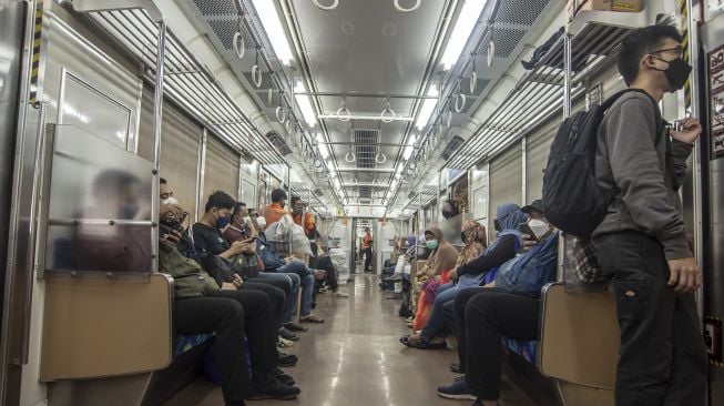 Penumpang duduk tanpa berjarak di dalam KRL Commuter Line, Jakarta, Rabu (9/3/2022).  ANTARA FOTO/Muhammad Adimaja
