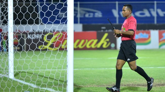 Asisten wasit tambahan memeriksa kondisi gawang saat pertandingan Liga 1 antara Arema FC melawan Persib Bandung di Stadion I Gusti Ngurah Rai, Denpasar, Bali, Rabu (9/3/2022).  ANTARA FOTO/Fikri Yusuf/aww.