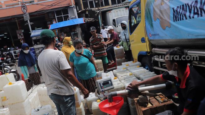 Sejumlah pedagang mengantre untuk mendapatkan minyak goreng curah di Pasar Kebayoran Lama, Jakarta, Rabu (9/3/2022). [Suara.com/Angga Budhiyanto] 