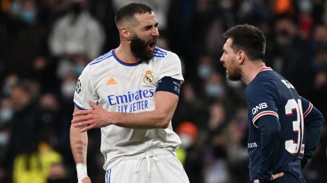 Pemain depan Real Madrid Karim Benzema (kiri) bereaksi di sebelah pemain depan Paris Saint-Germain Lionel Messi selama pertandingan sepak bola liga kedua babak 16 besar Liga Champions antara Real Madrid melawan Paris Saint-Germain di Stadion Santiago Bernabeu,  Kamis (10/3/2022) dini hari WIB.   GABRIEL BOUYS / AFP