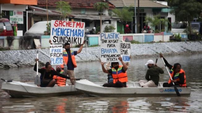 Aktivis lingkungan menggelar aksi di tengah Kalimas Surabaya [SuaraJatim/Dimas Angga]