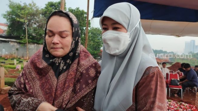 Asma Nadia (kanan) mendampingi Dewi Natalia, istri almarhum Hilman Hariwijaya ketika diwawancara awak media di TPU Jombang, Tangsel, Rabu (9/3/2022). Penulis Lupus Hilman Hariwijaya meninggal dunia di RSCM. [Suara.com/Wivy Hikmatulah]