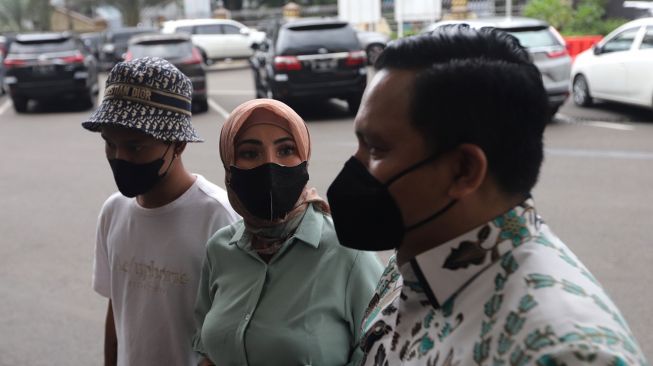 Model Ayu Aulia (tengah) memberikan keterangan pers setibanya di Polres Metro Jakarta Selatan, Kamis (10/3/2022). [Suara.com/Angga Budhiyanto]