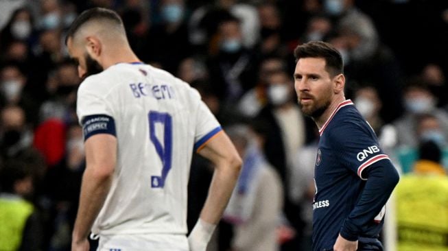 Penyerang Paris Saint-Germain Argentina Lionel Messi (kanan) melihat ke arah penyerang Real Madrid asal Prancis Karim Benzema selama pertandingan sepak bola liga kedua babak 16 besar Liga Champions antara Real Madrid melawan Paris Saint-Germain di Stadion Santiago Bernabeu,  Kamis (10/3/2022) dini hari WIB. GABRIEL BOUYS / AFP