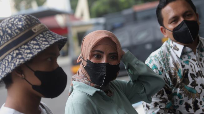 Model Ayu Aulia (tengah) memberikan keterangan pers setibanya di Polres Metro Jakarta Selatan, Kamis (10/3/2022). [Suara.com/Angga Budhiyanto]