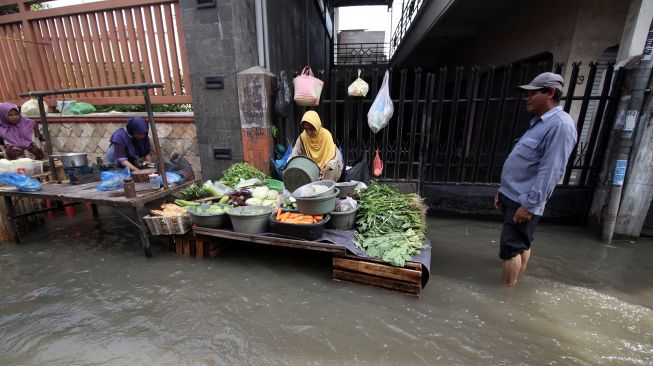 Pedagang berjualan meski banjir menggenangi Pasar Waru, Sidoarjo, Jawa Timur, Jumat (11/3/2022). ANTARA FOTO/Umarul Faruq


