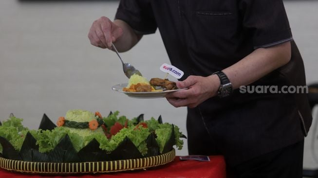 Komisaris Utama PT Arkadia Digital Media Stephen K.Sulistyo memotong tumpeng saat ulang tahun ke-8 Suara.com di Kantor Redaksi Suara.com, Mega Kuningan, Jakarta, Jumat (11/3/2022). [Suara.com/Angga Budhiyanto]