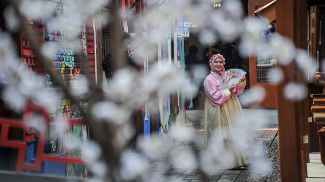 Warga memakai pakaian tradisional Korea saat mengunjungi Kampung Korea di Kiara Artha Park, Bandung, Jawa Barat, Sabtu (12/3/2022).  ANTARA FOTO/Raisan Al Farisi
