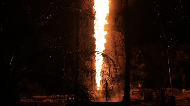 Api membumbung dari sumur minyak ilegal di kawasan pemukiman penduduk Desa Mata Ie, Kecamatan Ranto Peureulak, Aceh Timur, Sabtu (12/3/2022). ANTARA FOTO/Syifa Yulinnas