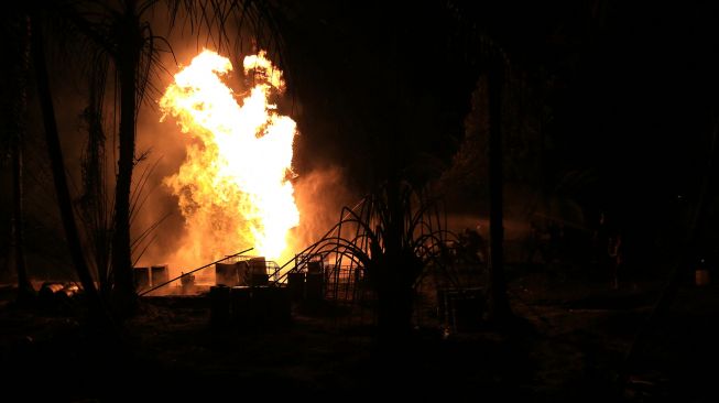 Api membumbung dari sumur minyak ilegal di kawasan pemukiman penduduk Desa Mata Ie, Kecamatan Ranto Peureulak, Aceh Timur, Sabtu (12/3/2022). ANTARA FOTO/Syifa Yulinnas