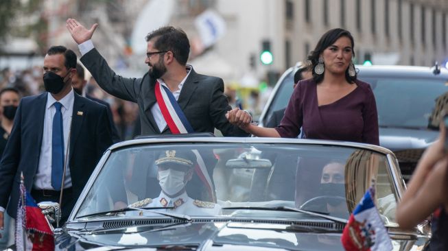 PFoto yang dirilis oleh Kepresidenan Chili, Presiden baru Chili Gabriel Boric (kiri) dan Menteri Dalam Negerinya Izkia Siches saat tiba di Istana La Moneda setelah upacara pelantikannya di Santiago, Chili, Jumat (11/3/2022). [Kantor Kepresidenan Chili / AFP]