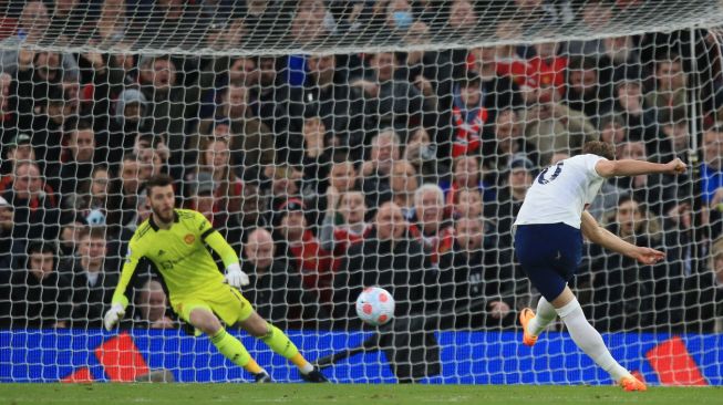 Striker Tottenham Hotspur Harry Kane (kanan) mencetak dari titik penalti saat pertandingan sepak bola Liga Premier Inggris antara Manchester United dan Tottenham Hotspur di Stadion Old Trafford, Manchester, Inggris, Sabtu (12/3/2022). [Lindsey Parnaby / AFP]