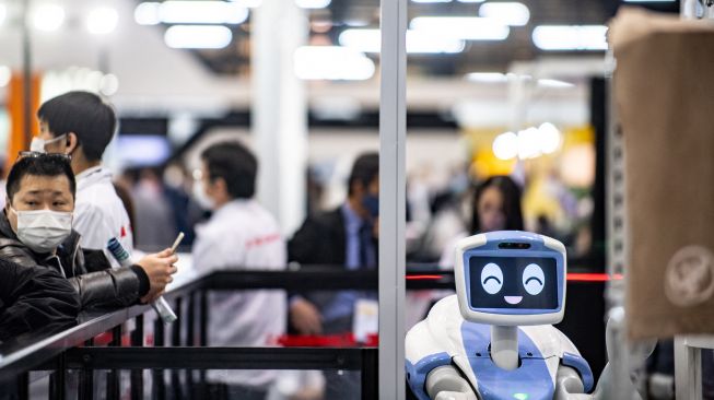 Pengunjung melihat demonstrasi robot industri yang dikembangkan Kawasaki Heavy Industries Ltd saat Pameran Robot Internasional di Tokyo, Jepang, Kamis (10/3/2022). [Philip FONG/AFP]