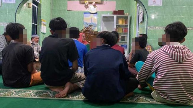 Warga menyaksikan permohonan maaf yang disampaikan tujuh remaja yang melecehkan Alquran di Surau Nurul Haq, Kota Tanjungpinang, Sabtu (12/3/2022) malam. [ANTARA/Nikolas Panama]